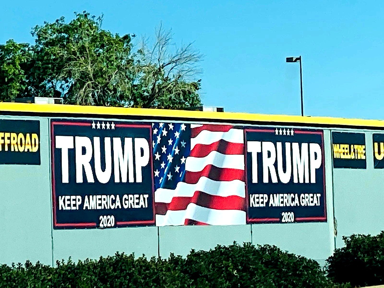 A large Trump sign on the side of a blue wall