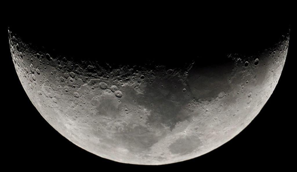 A photograph showcasing the Moon as a shadow covers its top half
