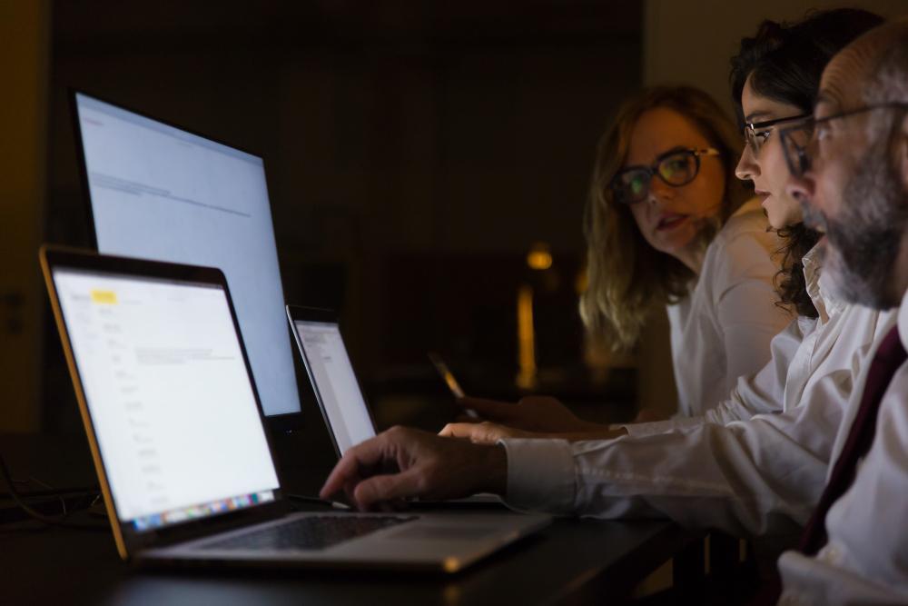 A photograph of several researchers seated at their desks working on laptops