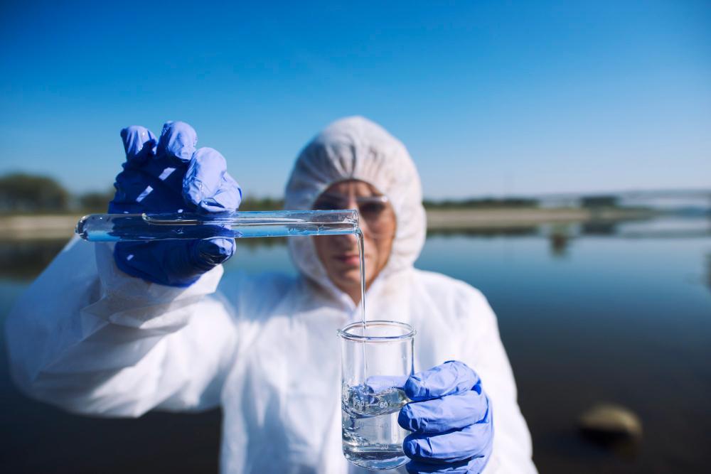 A photograph of a scientist taking a water sample
