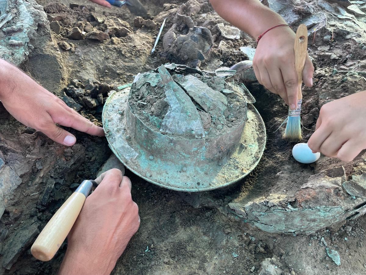 A photograph of several archaeologists pictured excavating the remains of a tomb