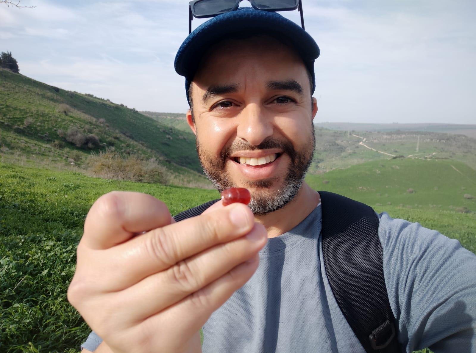 A photograph of Avrahamov holding the small amulet