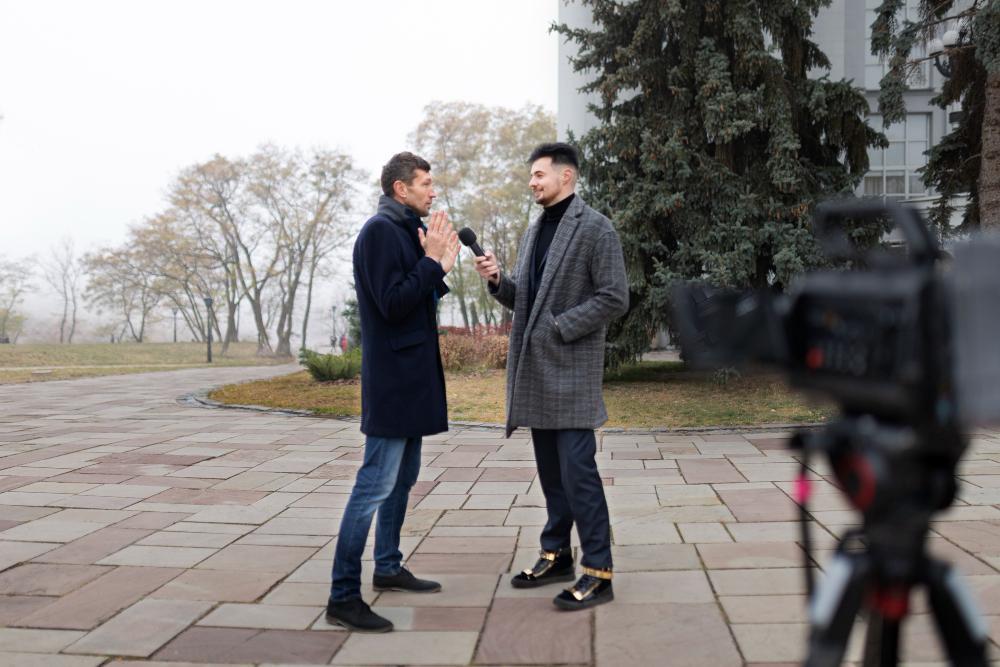 A photograph of a reporter interviewing a man