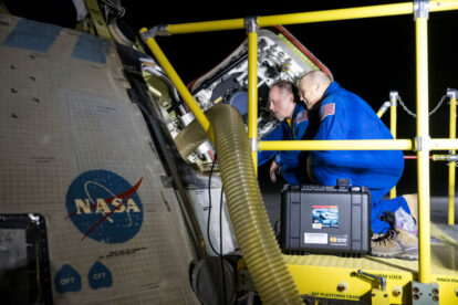 This handout image supplied by NASA shows NASA astronauts Mike Fincke, left, and Scott Tingle look inside NASA's Boeing Crew Flight Test Starliner spacecraft after it landed uncrewed at White Sands Missile Range's Space Harbor, on September 6, 2024 at White Sands, New Mexico. This approach allows NASA and Boeing to continue gathering testing data on the spacecraft.